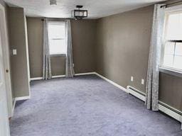 unfurnished room with baseboard heating