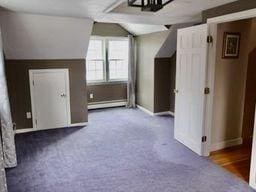 bonus room with vaulted ceiling, a baseboard radiator, and dark colored carpet