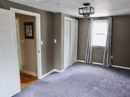 unfurnished room with dark carpet