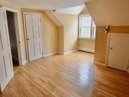 additional living space featuring lofted ceiling and light hardwood / wood-style flooring