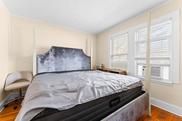 bedroom with baseboards and wood finished floors