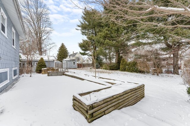 yard covered in snow featuring an outbuilding and a storage unit