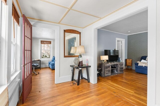 foyer featuring crown molding, baseboards, and wood finished floors