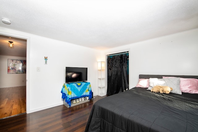 bedroom featuring a textured ceiling and dark hardwood / wood-style flooring