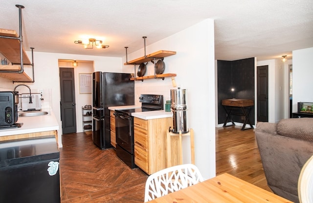 kitchen with a textured ceiling, black appliances, and dark wood-type flooring