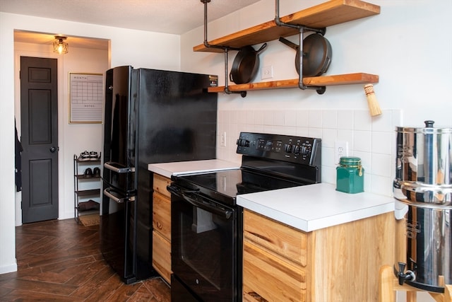 kitchen with dark parquet floors, black appliances, a textured ceiling, and backsplash