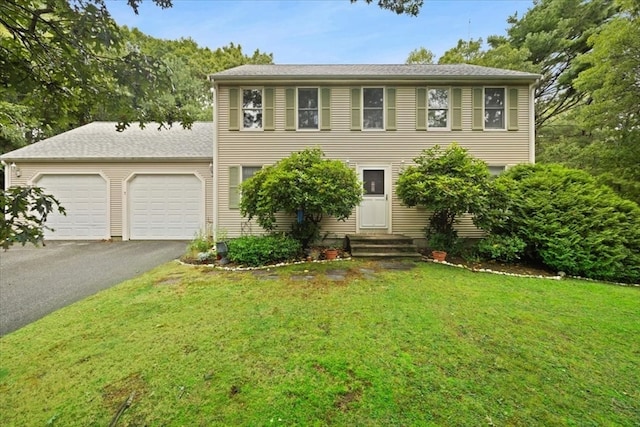 colonial house with a front lawn and a garage