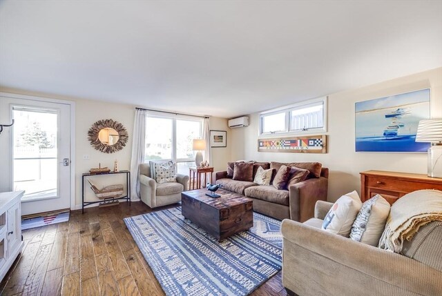 living area with dark wood-type flooring and a wall unit AC