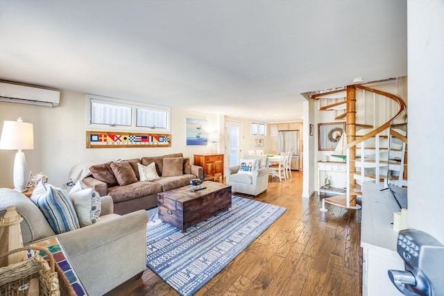 living area featuring a wall mounted air conditioner, wood-type flooring, and stairway