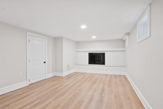 2028 Main St, Concord, MA 01742 - basement featuring wood finished floors, a glass covered fireplace, and recessed lighting