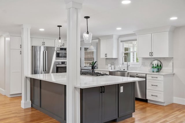 2028 Main St, Concord, MA 01742 - kitchen with appliances with stainless steel finishes, decorative columns, white cabinetry, a kitchen island, and recessed lighting