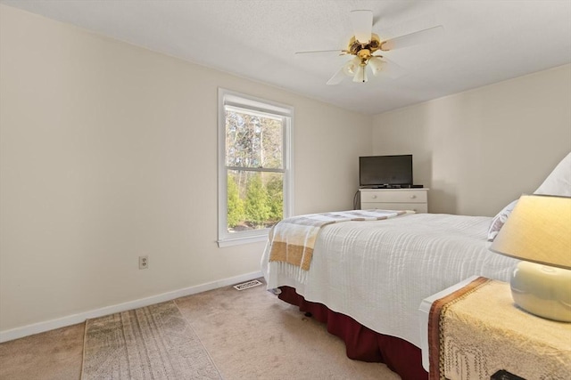 carpeted bedroom with visible vents, baseboards, and multiple windows