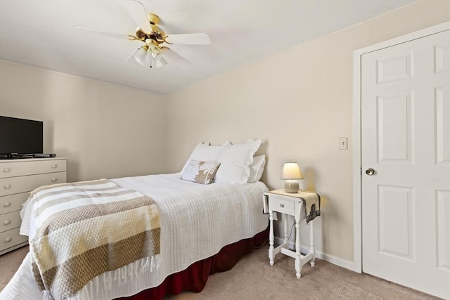 carpeted bedroom featuring baseboards and a ceiling fan
