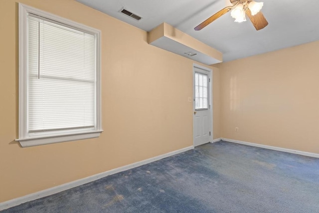 unfurnished room featuring visible vents, a ceiling fan, baseboards, and carpet