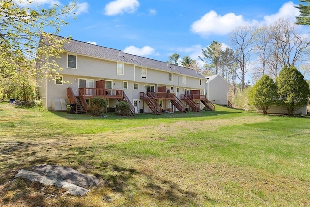 back of house with a wooden deck, a yard, and stairway