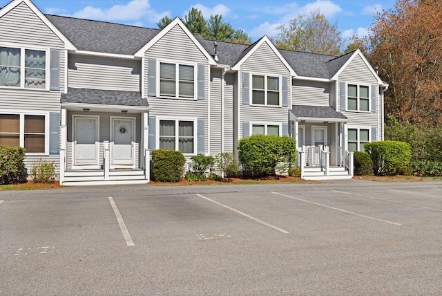 multi unit property featuring uncovered parking and roof with shingles