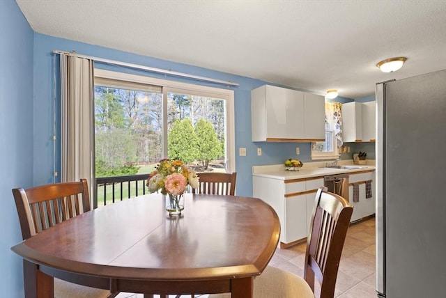 dining space featuring light tile patterned flooring and a textured ceiling