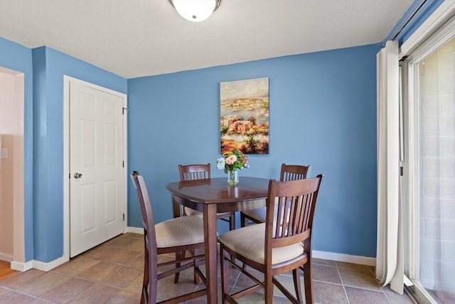 dining area featuring baseboards and a textured ceiling