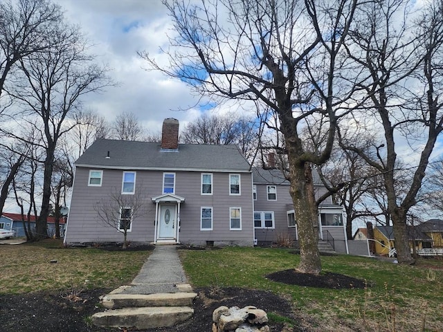 colonial home with a front lawn