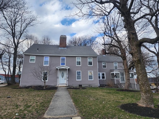 colonial inspired home with a front lawn