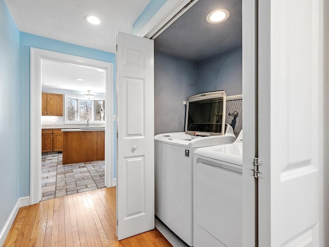 laundry area with laundry area, baseboards, light wood-style flooring, separate washer and dryer, and recessed lighting