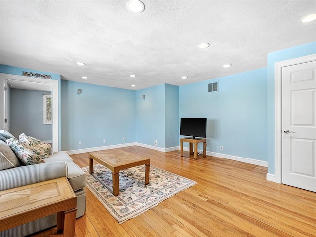 living area featuring light wood finished floors, recessed lighting, visible vents, and baseboards