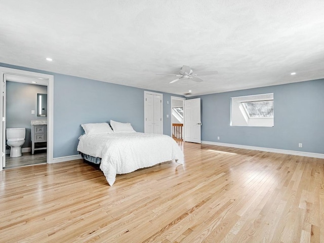 bedroom featuring light wood finished floors, recessed lighting, a ceiling fan, ensuite bath, and baseboards