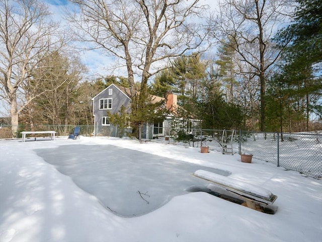 yard layered in snow featuring fence