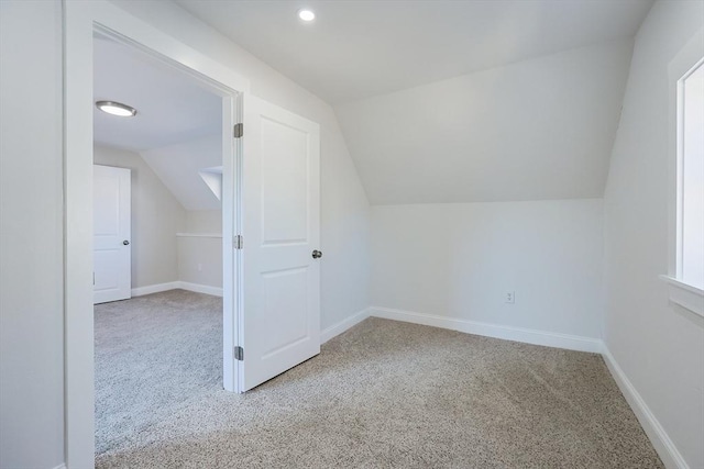 bonus room featuring lofted ceiling and light carpet