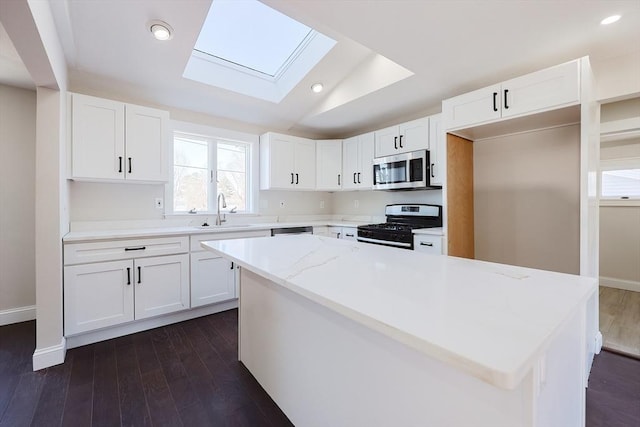 kitchen with white cabinets, appliances with stainless steel finishes, and a center island