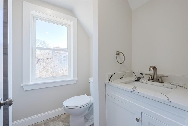 bathroom featuring toilet, vanity, and vaulted ceiling