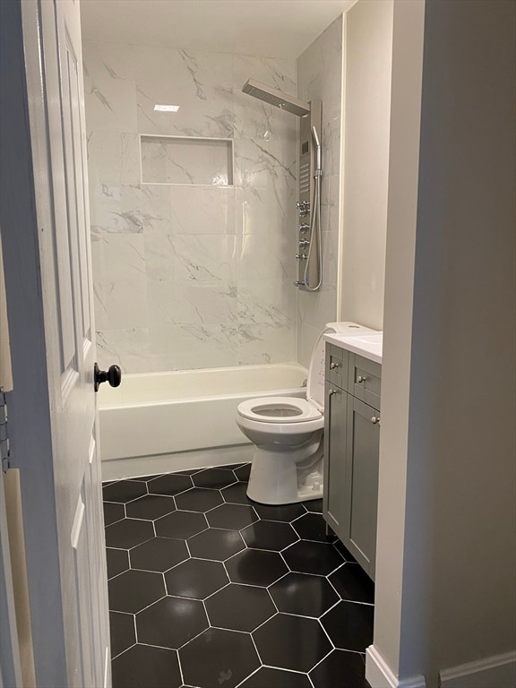 full bathroom with toilet, vanity, tiled shower / bath, and tile flooring