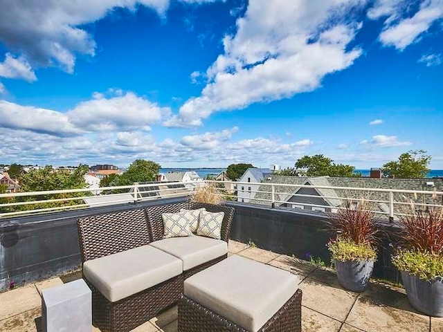 view of patio featuring a balcony and a water view