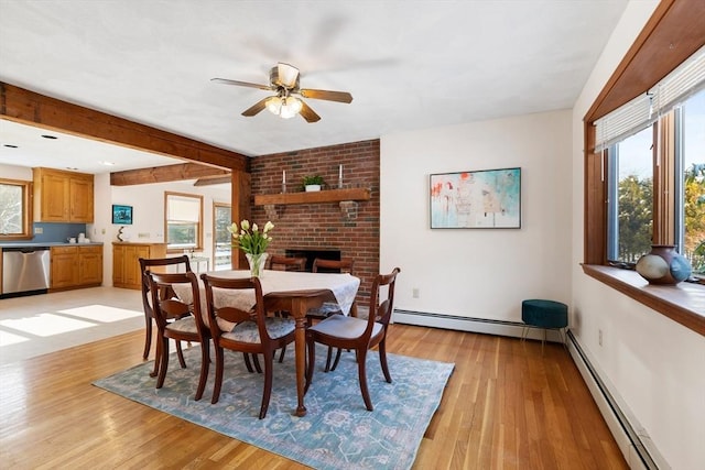 dining room with a baseboard heating unit, light hardwood / wood-style floors, and beamed ceiling