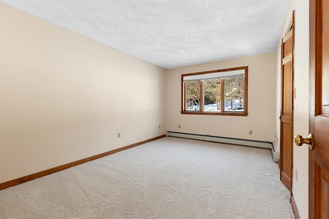 empty room with a baseboard heating unit and light carpet