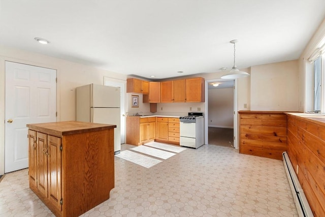 kitchen featuring pendant lighting, a baseboard radiator, sink, a center island, and white appliances