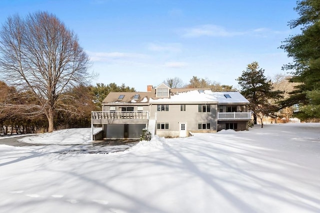 snow covered rear of property featuring a wooden deck