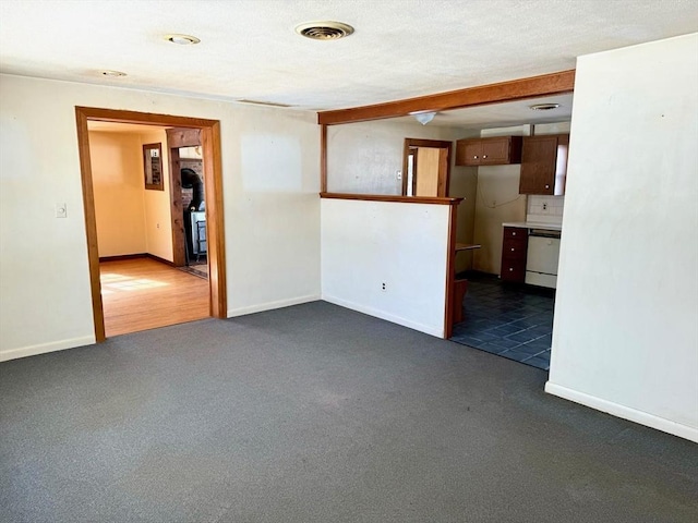 empty room featuring dark colored carpet, visible vents, and baseboards