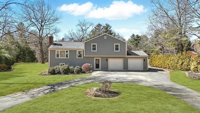 tri-level home with a front yard, driveway, and a chimney