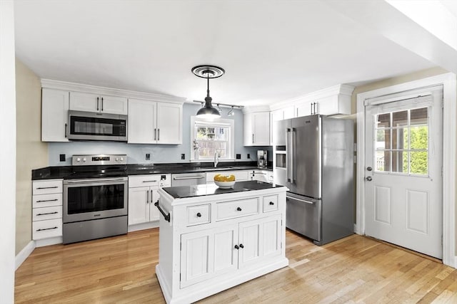 15 Maple St, Salem, MA 01970 - kitchen with stainless steel appliances, dark countertops, white cabinets, and a center island