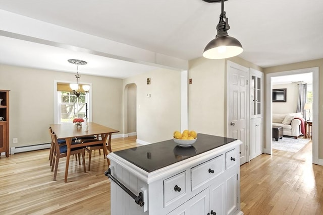 15 Maple St, Salem, MA 01970 - kitchen featuring arched walkways, light wood-type flooring, white cabinetry, and pendant lighting