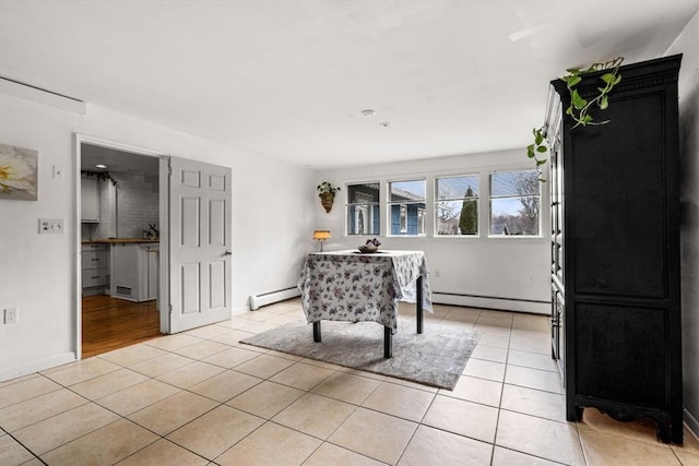 dining space with light tile patterned floors and a baseboard heating unit