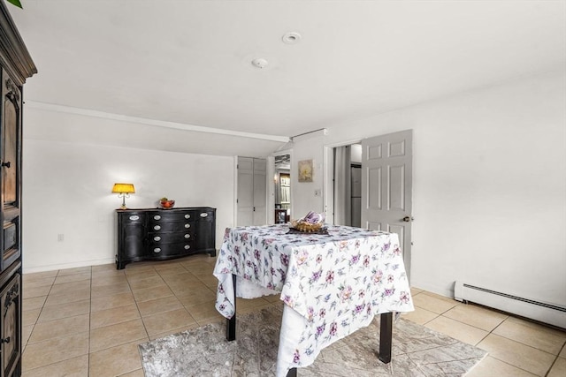 bedroom featuring lofted ceiling, light tile patterned floors, and baseboard heating