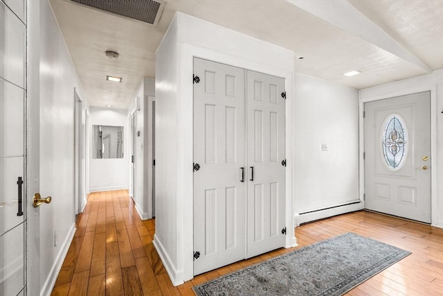 entryway featuring visible vents, baseboards, wood-type flooring, and a baseboard radiator