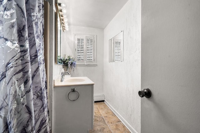 full bathroom with vanity, baseboards, and a textured wall