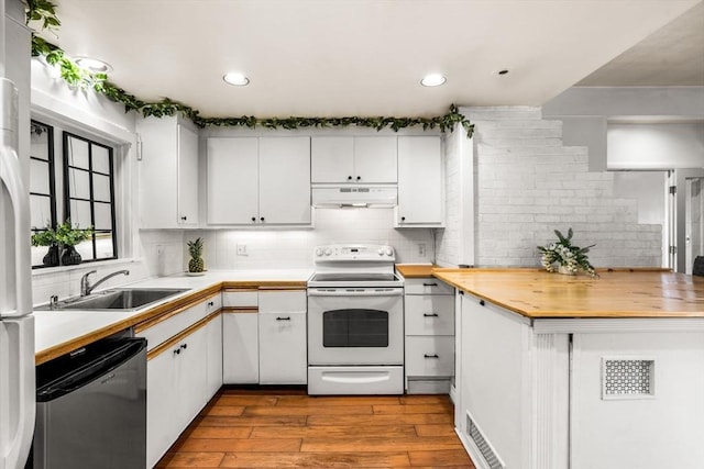 kitchen with under cabinet range hood, dishwashing machine, white cabinets, white electric range, and a sink