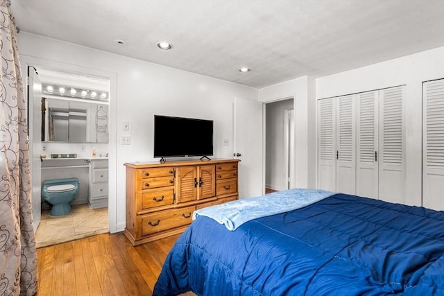 bedroom featuring recessed lighting, wood finished floors, and ensuite bathroom