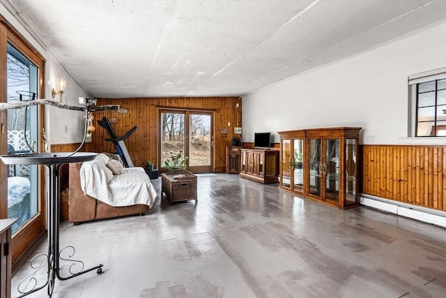 unfurnished living room with wood finished floors, wooden walls, and a healthy amount of sunlight