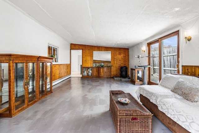 living room with a baseboard heating unit, wood walls, and wainscoting