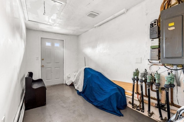 interior space with electric panel, visible vents, baseboard heating, and concrete flooring